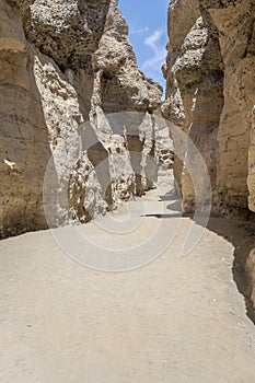 worn sandstone cliffs on sand dry riverbed at narrow Serisem canyon, Naukluft desert, Namibia