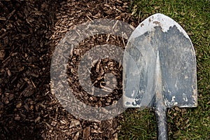 Worn shovel on a background of dirt and grass