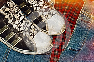 Worn sneakers on the denim jacket ans checkered shirt