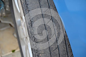 Worn tire of a blue car detail photo