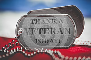 Worn US American dog tags on USA flag with Thank a Veteran Today text