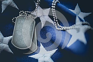 Worn USA military dog tags close up on US American flag with space for text