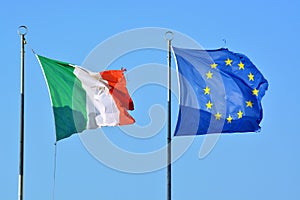 Worn waving flags of Italy and Europe