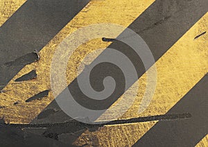 Worn weathered surface with diagonal yellow and black stripes.