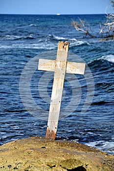 Worn Wooden Cross Surrounded by the Sea