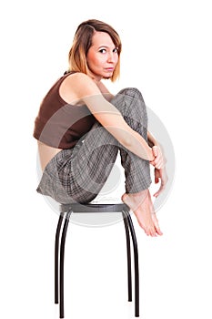 Worried and afraid young woman sitting on chair. Isolated