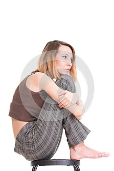 Worried and afraid young woman sitting on chair. Isolated