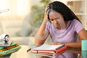 Worried black student memorizing notes at home photo