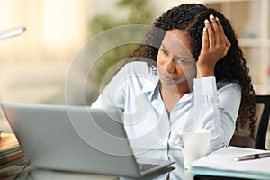 Worried black teleworker working at home photo