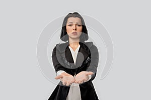 Worried business lady giving a helping palms, asking or offering help, standing over white background. Business concept for asking