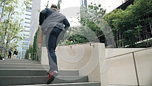 Worried business man running up stairs with hurry at green eco city. Urbane.