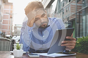 Worried business man working on digital tablet