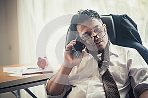 Worried business man at workplace in office after tired from hard work.