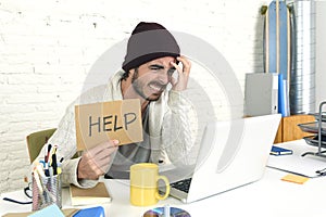 Worried businessman in cool hipster beanie look holding help sign working in stress at home office