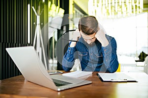 Worried businessman lamenting in front of a computer after a big mistake at office