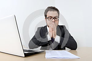 Worried businessman with laptop and document