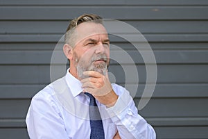 Worried businessman looking aside in deep contemplation