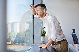 Worried businessman at office looking out the window