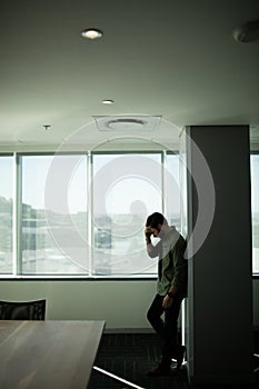 Worried businessman standing by window