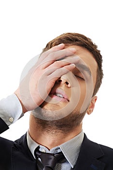 Worried businessman touching his forehead.