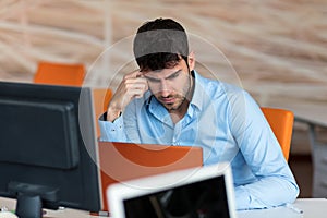 Worried businessman working at his desk in his office