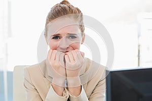 Worried businesswoman bitting nails at office