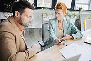 worried businesswoman pointing at charts while