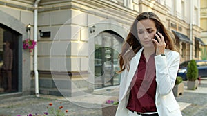 Worried businesswoman receiving bad news by mobile phone outdoors