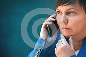 Worried businesswoman talking on mobile phone