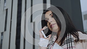 Businesswoman talking on smartphone at street. Employee using mobile phone