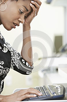 Worried Businesswoman Typing On Computer Keyboard