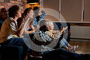 Worried cheering friends or basketball fans watching basketball game on tv at home.Friendship, sports and entertainment