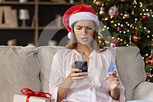 Worried concerned girl in Christmas Santa hat having problems