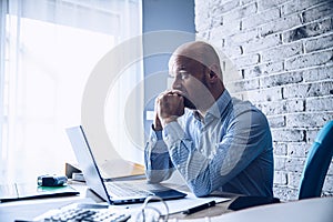 Worried confused man in shirt working on laptop computer