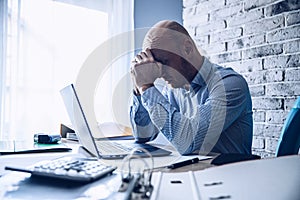 Worried confused man in shirt working on laptop computer