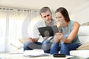 Worried couple checking bank account online