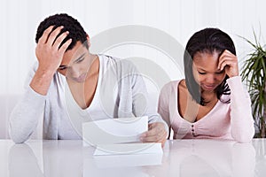 Worried Couple Looking At Paper