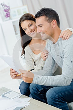 Worried couple reading important notification in letter