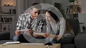 Worried couple reading a letter at home