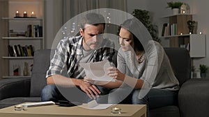 Worried couple reading a letter at home