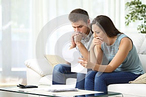 Worried couple reading a letter photo