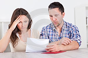 Worried couple reading paper