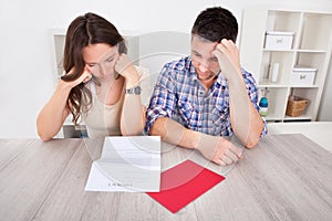 Worried couple reading paper