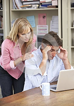 Worried Couple Working In Home Office Together