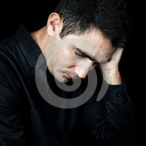 Worried and depressed man isolated on black