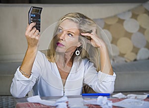 Worried and desperate blond woman calculating domestic money exp