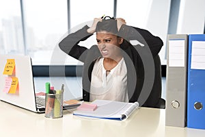Worried and desperate businesswoman suffering stress working at office computer desk