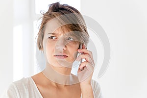 Worried disturbed young woman talking on mobile phone