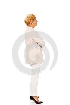 Worried elderly business woman with arms folded