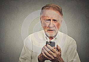 Worried elderly man looking at his smart phone